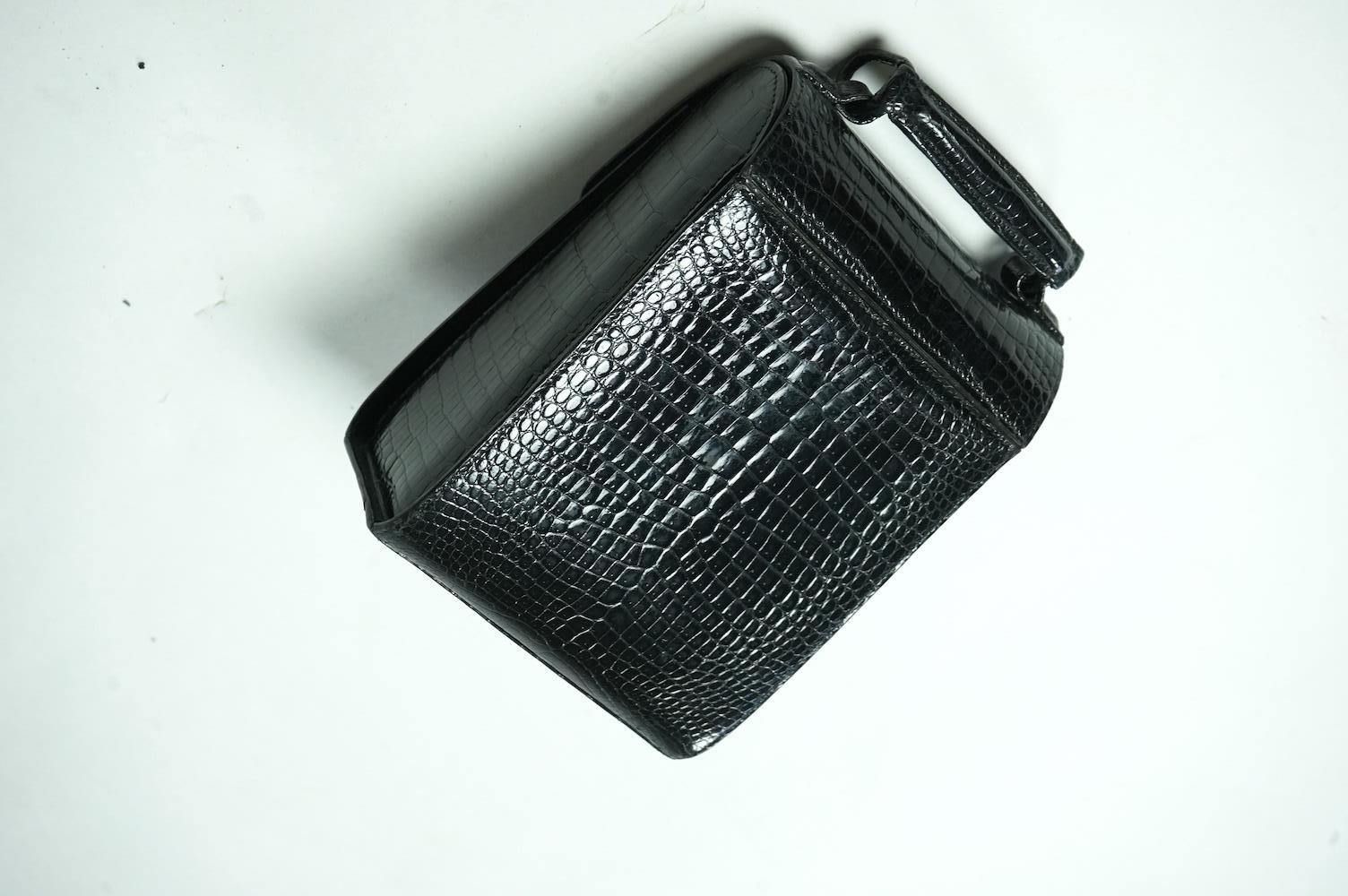 A stylish 1930’s lady’s Asprey of London, black lizard skin evening bag with ornamental amber coloured Bakelite clasp. 23cm high from handle to base. Condition- some internal scratches to lining as expected for age and u